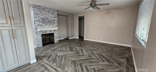 a view of empty room with fireplace and wooden floor