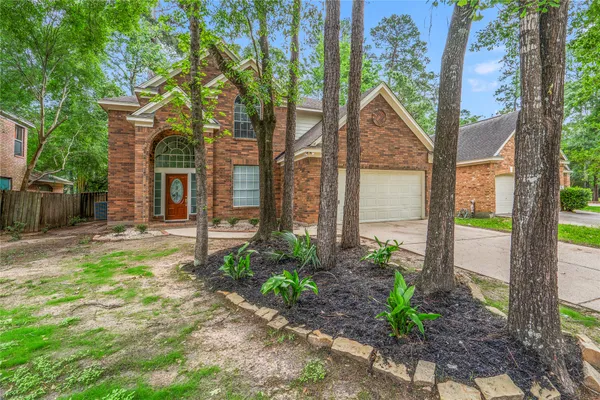 a view of a house with a yard and large tree