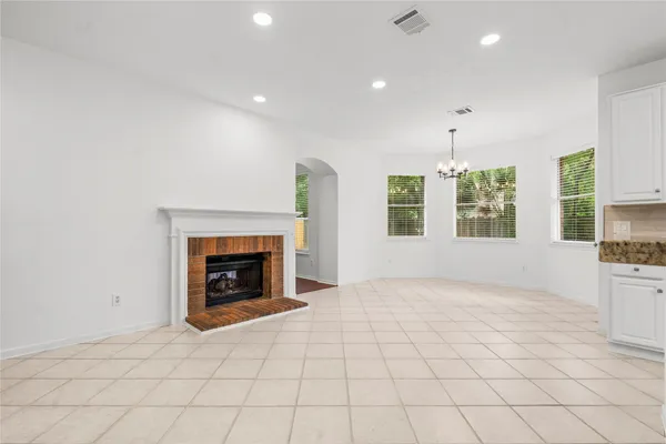 an empty room with windows and fireplace