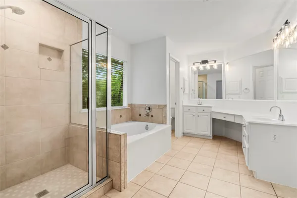 a bathroom with a tub sink shower and mirror