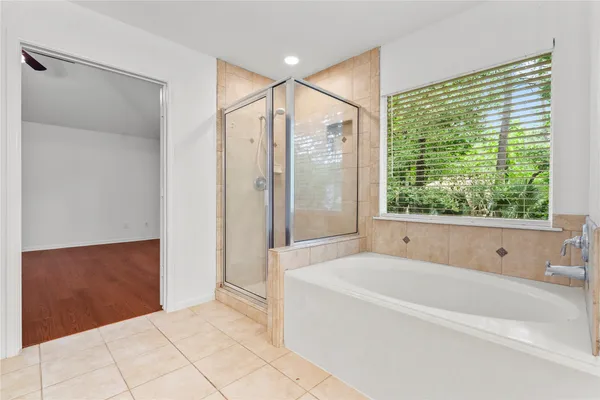 a bathroom with a large tub a shower and view