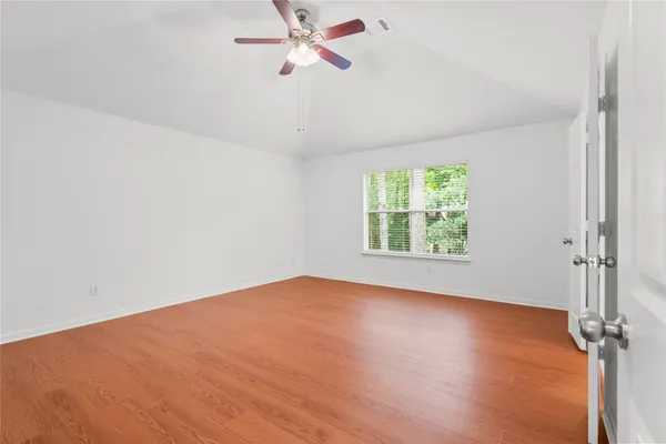 an empty room with a window and a ceiling fan