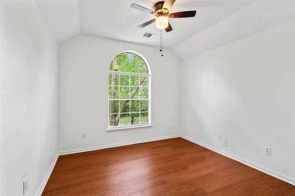 an empty room with a window and a fan