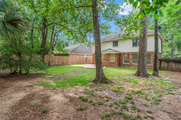 a view of a house with backyard and a tree