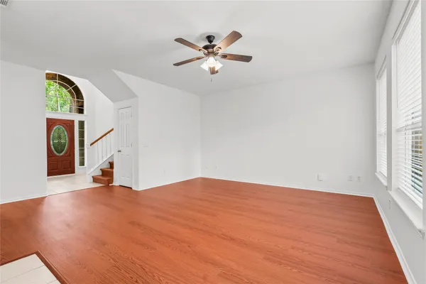 a view of an empty room with window and wooden floor