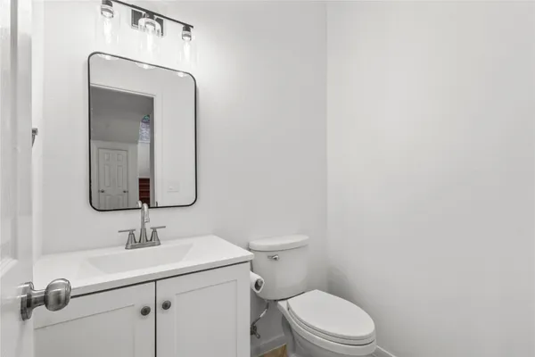a bathroom with a toilet a sink and mirror