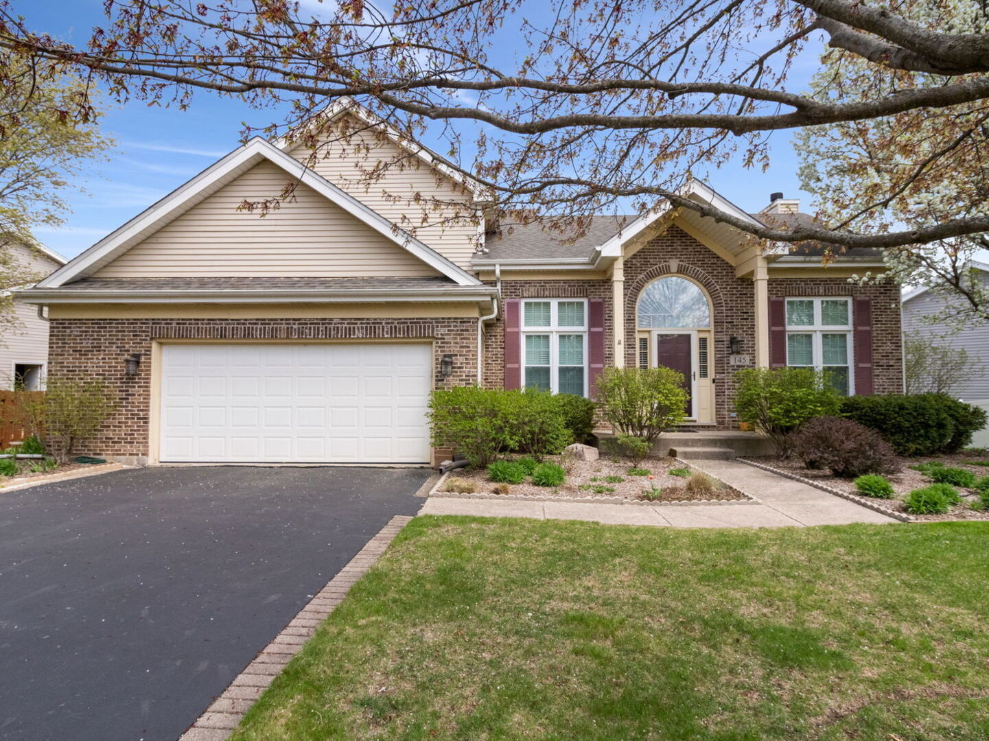 a front view of a house with a yard and potted plants