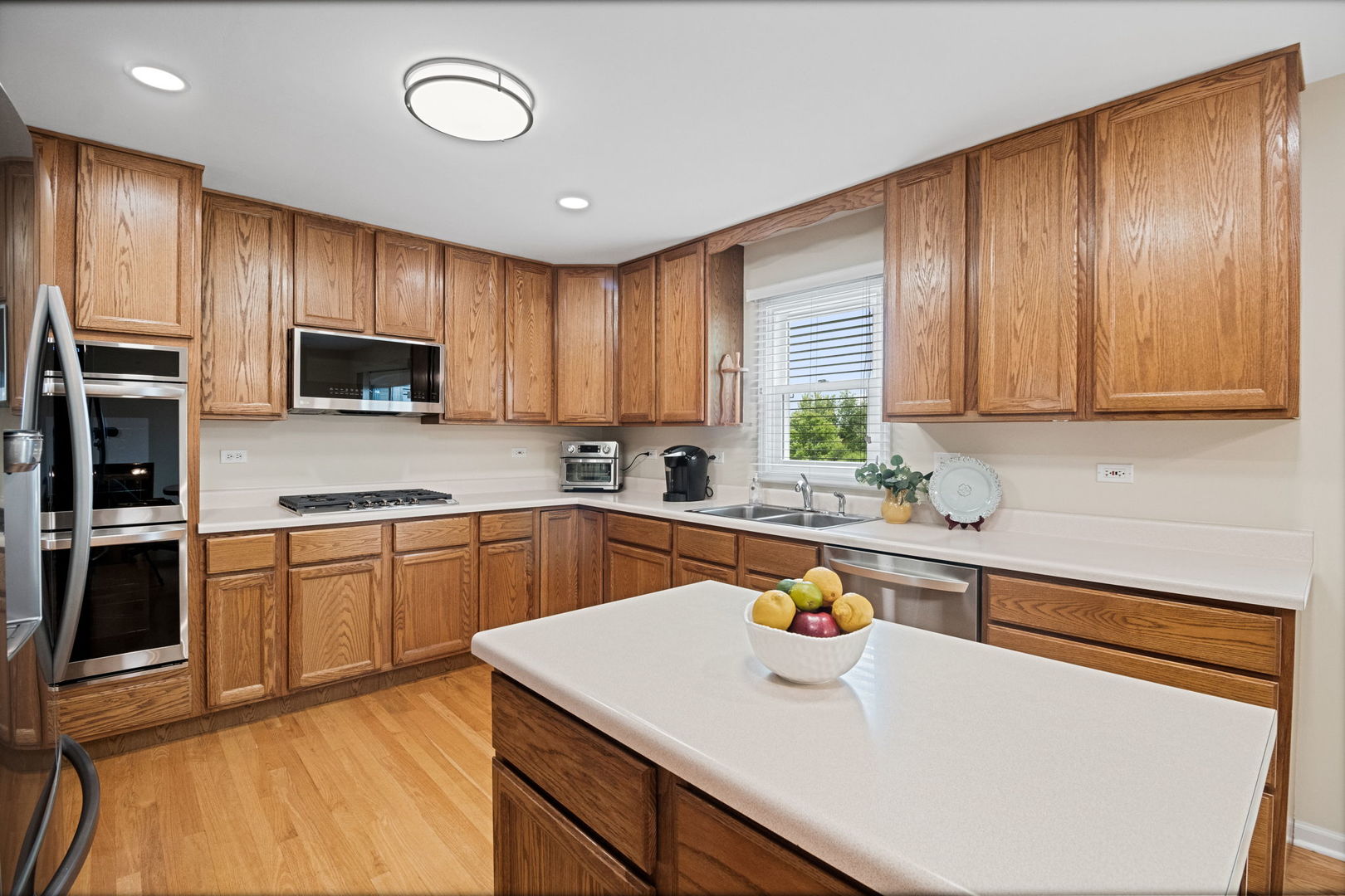 145 Barnes Road Elgin, IL 60124 - Photo 31 of 45 a kitchen with stainless steel appliances wooden cabinets a stove a sink and a refrigerator