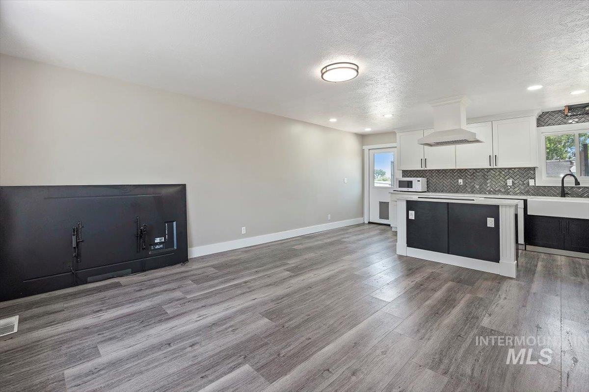 616 Doris Avenue Paul, ID 83347 - Photo 38 of 38 Kitchen featuring light countertops, white cabinetry, open floor plan, plenty of natural light, and a textured ceiling