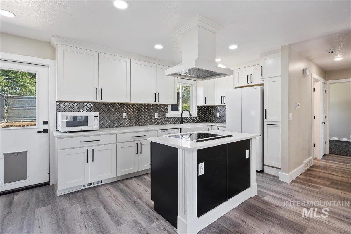 616 Doris Avenue Paul, ID 83347 - Photo 12 of 38 Kitchen featuring light countertops, ventilation hood, white appliances, white cabinets, and decorative backsplash