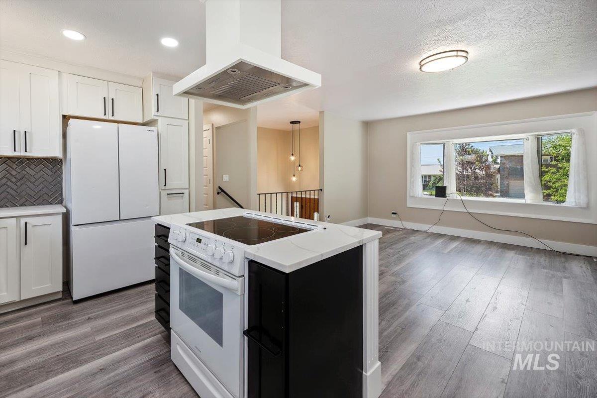 616 Doris Avenue Paul, ID 83347 - Photo 14 of 38 Kitchen with custom range hood, white appliances, light wood finished floors, tasteful backsplash, and recessed lighting