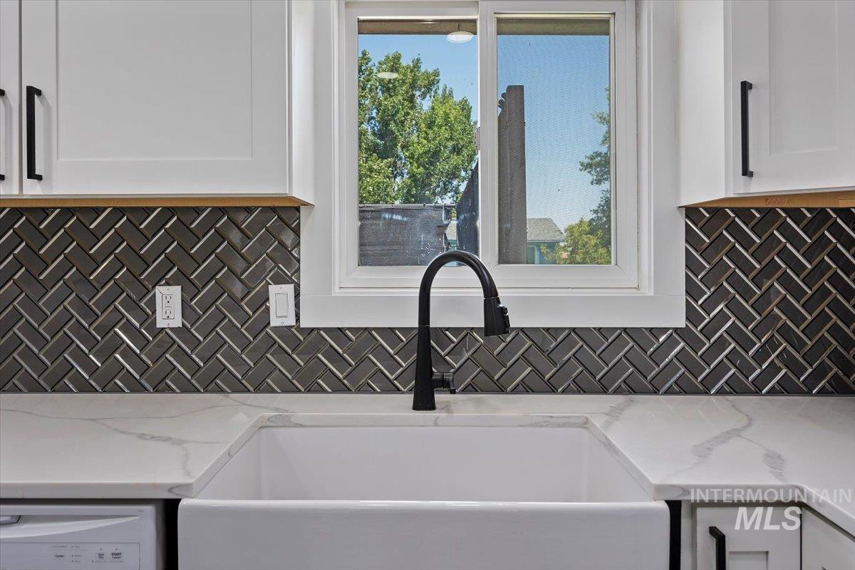 616 Doris Avenue Paul, ID 83347 - Photo 16 of 38 Kitchen featuring white cabinetry, backsplash, light stone countertops, and white dishwasher