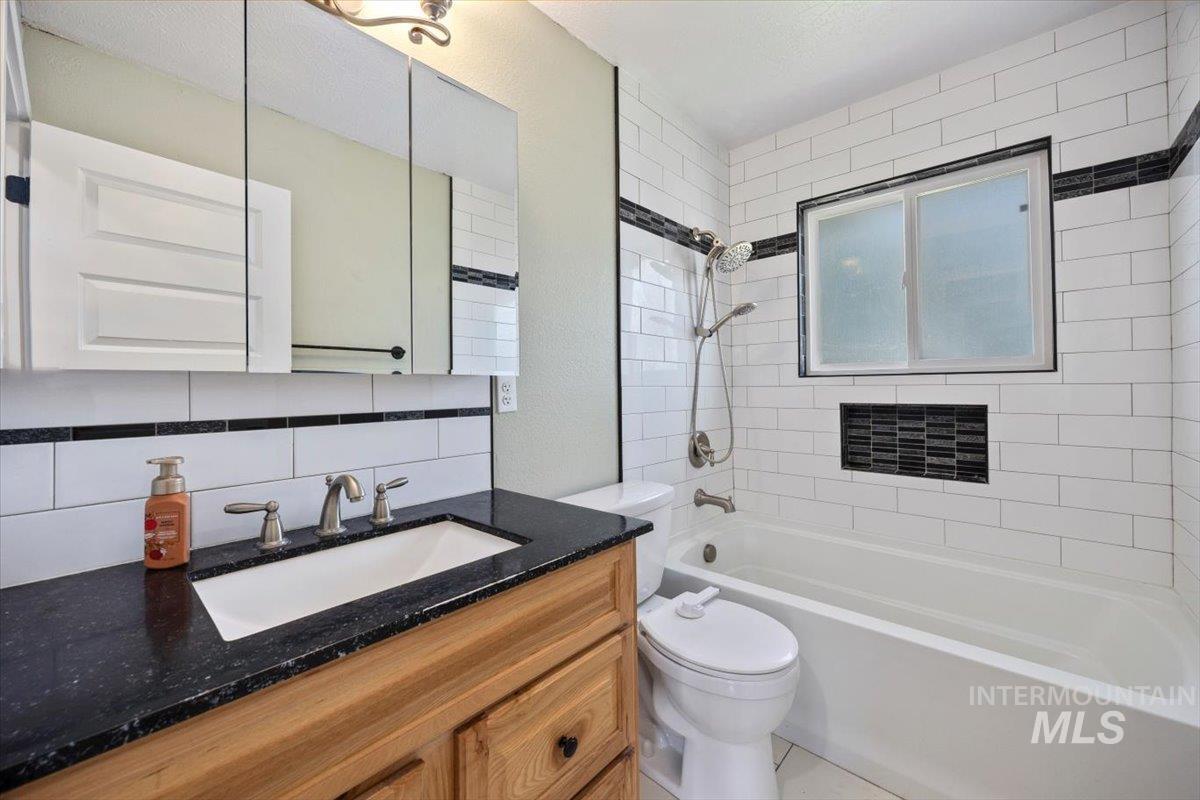 616 Doris Avenue Paul, ID 83347 - Photo 21 of 38 Bathroom with backsplash, vanity, and washtub / shower combination