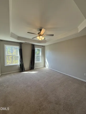 an empty room with windows and ceiling fan