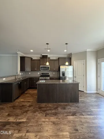 a kitchen with stainless steel appliances kitchen island granite countertop a stove and a sink