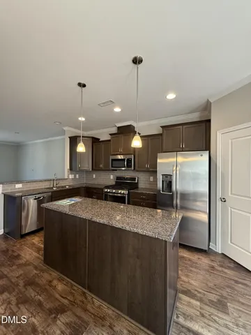 a kitchen with stainless steel appliances granite countertop a sink a counter space and cabinets