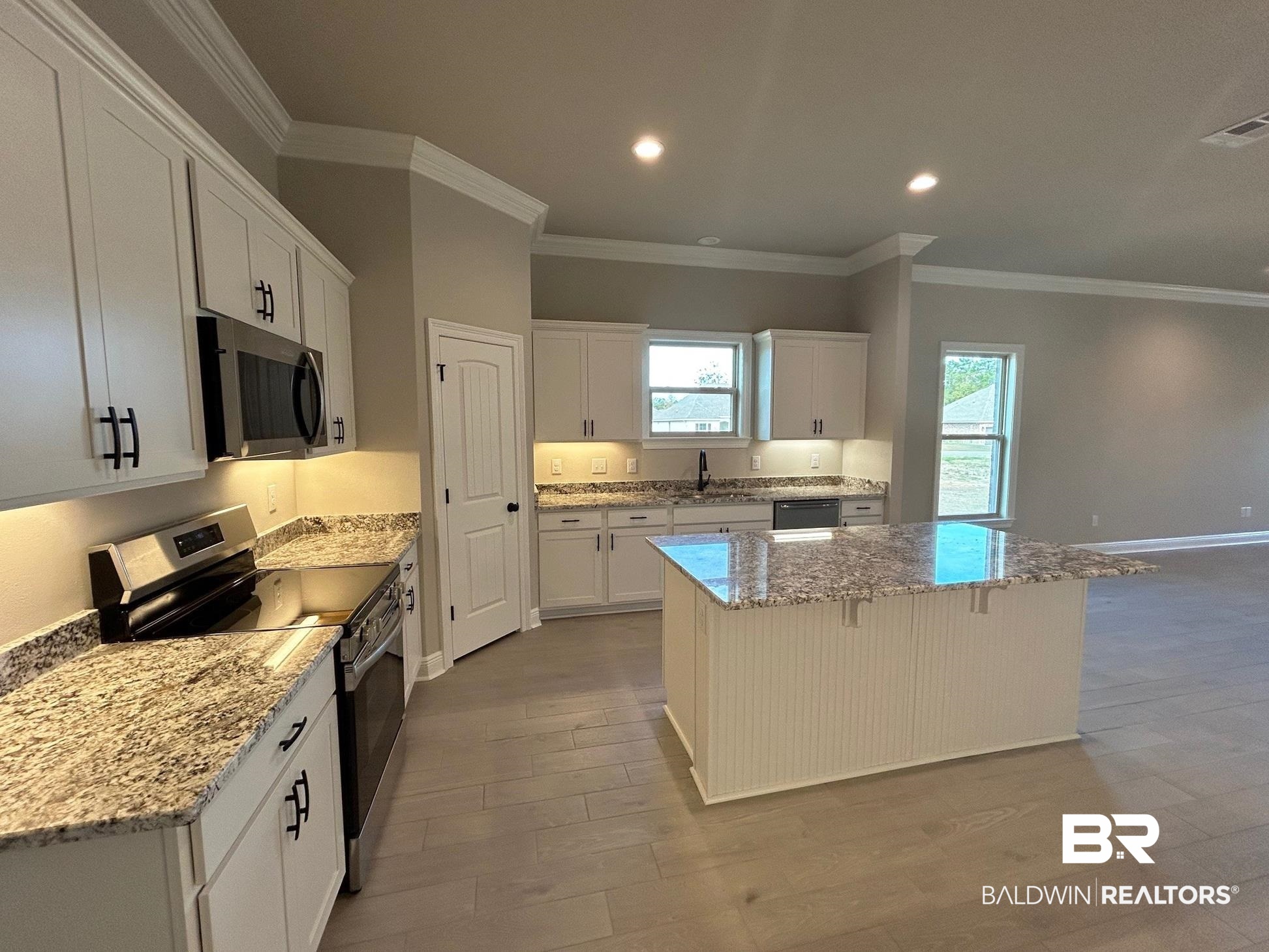 881 Sumter Loop Foley, AL 36535 - Photo 2 of 19 Kitchen with white cabinets, a center island, light stone countertops, and stainless steel appliances