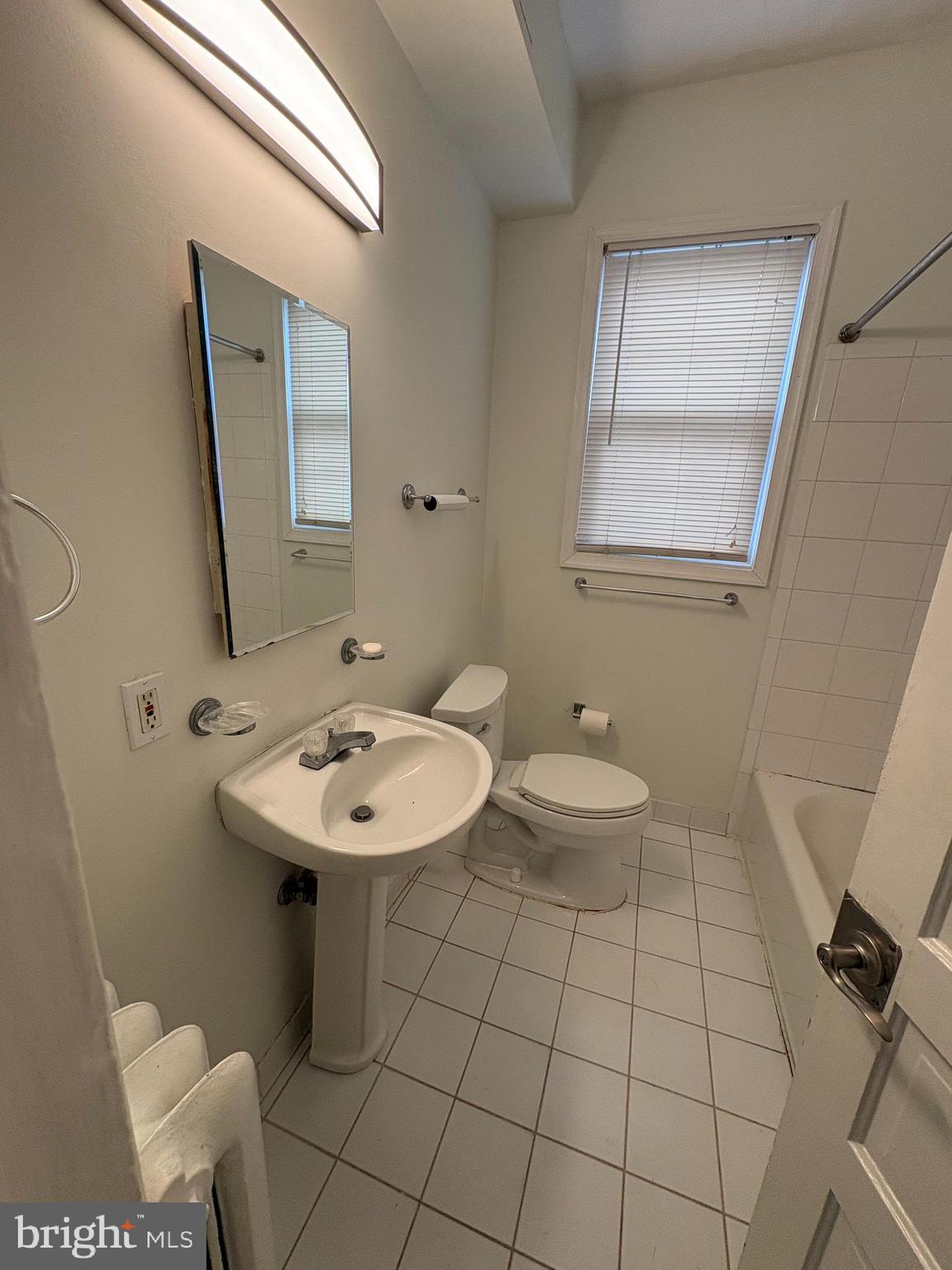 523 24th Street South Arlington, VA 22202 - Photo 6 of 18 a bathroom with a sink a toilet and mirror