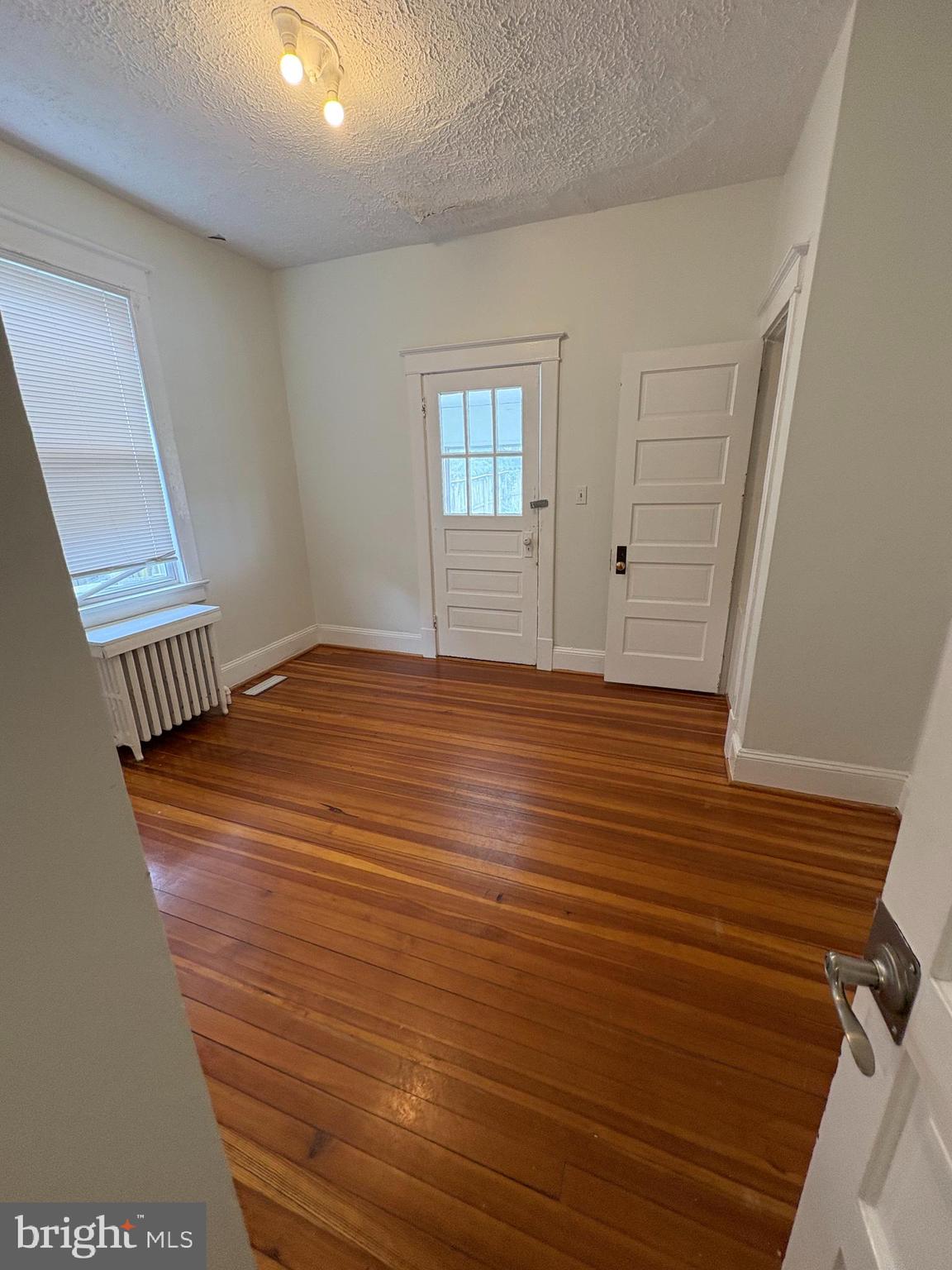 523 24th Street South Arlington, VA 22202 - Photo 9 of 18 a view of an empty room with window and hardwood floor