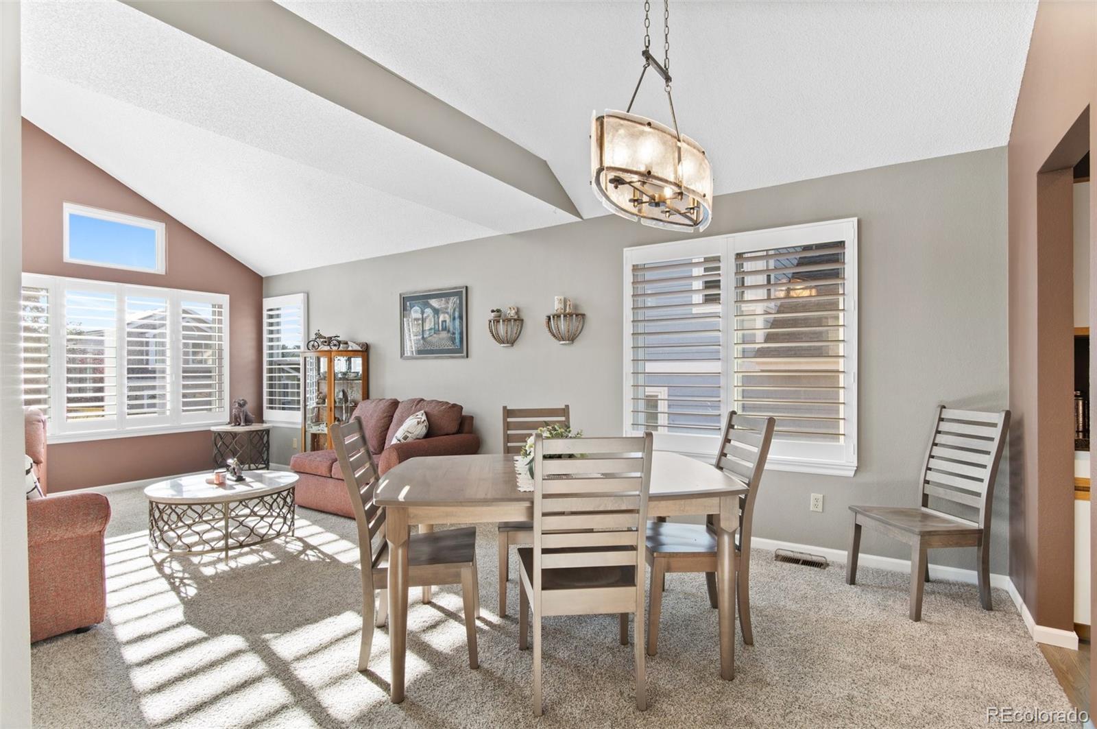 9836 Buckingham Court Highlands Ranch, CO 80130 - Photo 11 of 42 a view of a dining room with furniture wooden floor and a chandelier