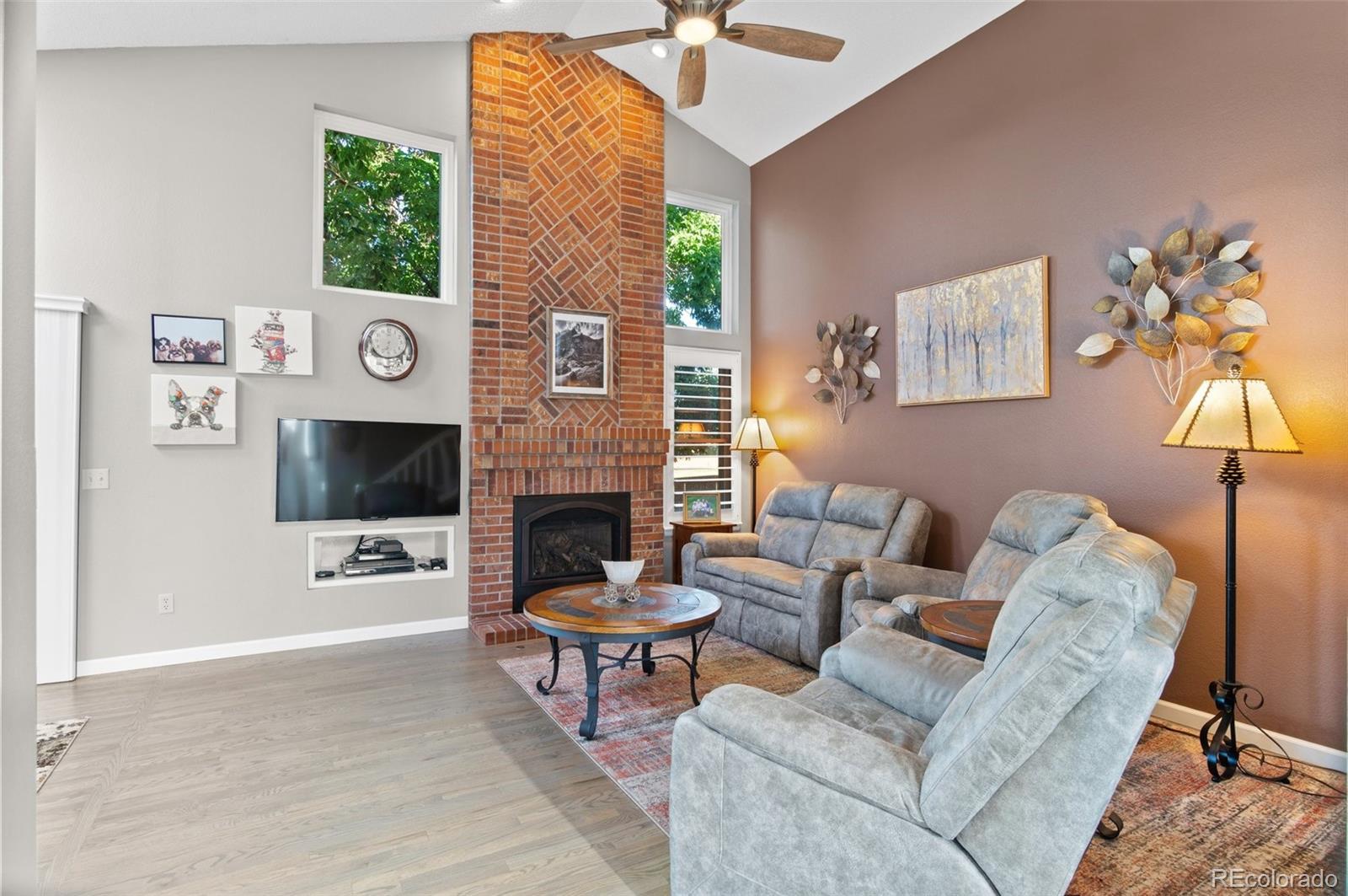9836 Buckingham Court Highlands Ranch, CO 80130 - Photo 13 of 42 a living room with furniture a flat screen tv and a fireplace