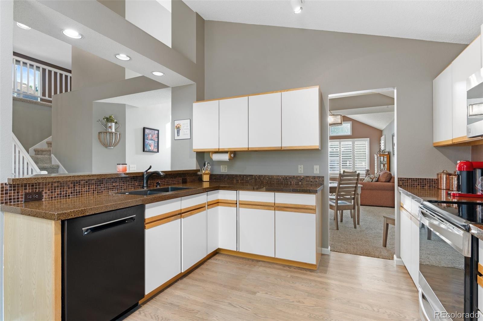 9836 Buckingham Court Highlands Ranch, CO 80130 - Photo 20 of 42 a kitchen with granite countertop cabinets stainless steel appliances a sink and a counter top space