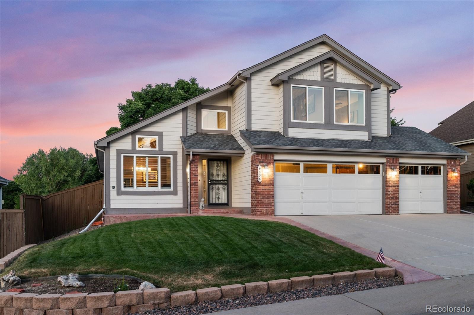 9836 Buckingham Court Highlands Ranch, CO 80130 - Photo 2 of 42 a front view of a house with a yard and garage