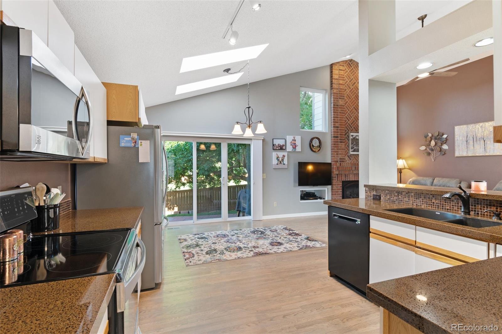 9836 Buckingham Court Highlands Ranch, CO 80130 - Photo 21 of 42 a kitchen with stainless steel appliances granite countertop a sink stove and refrigerator