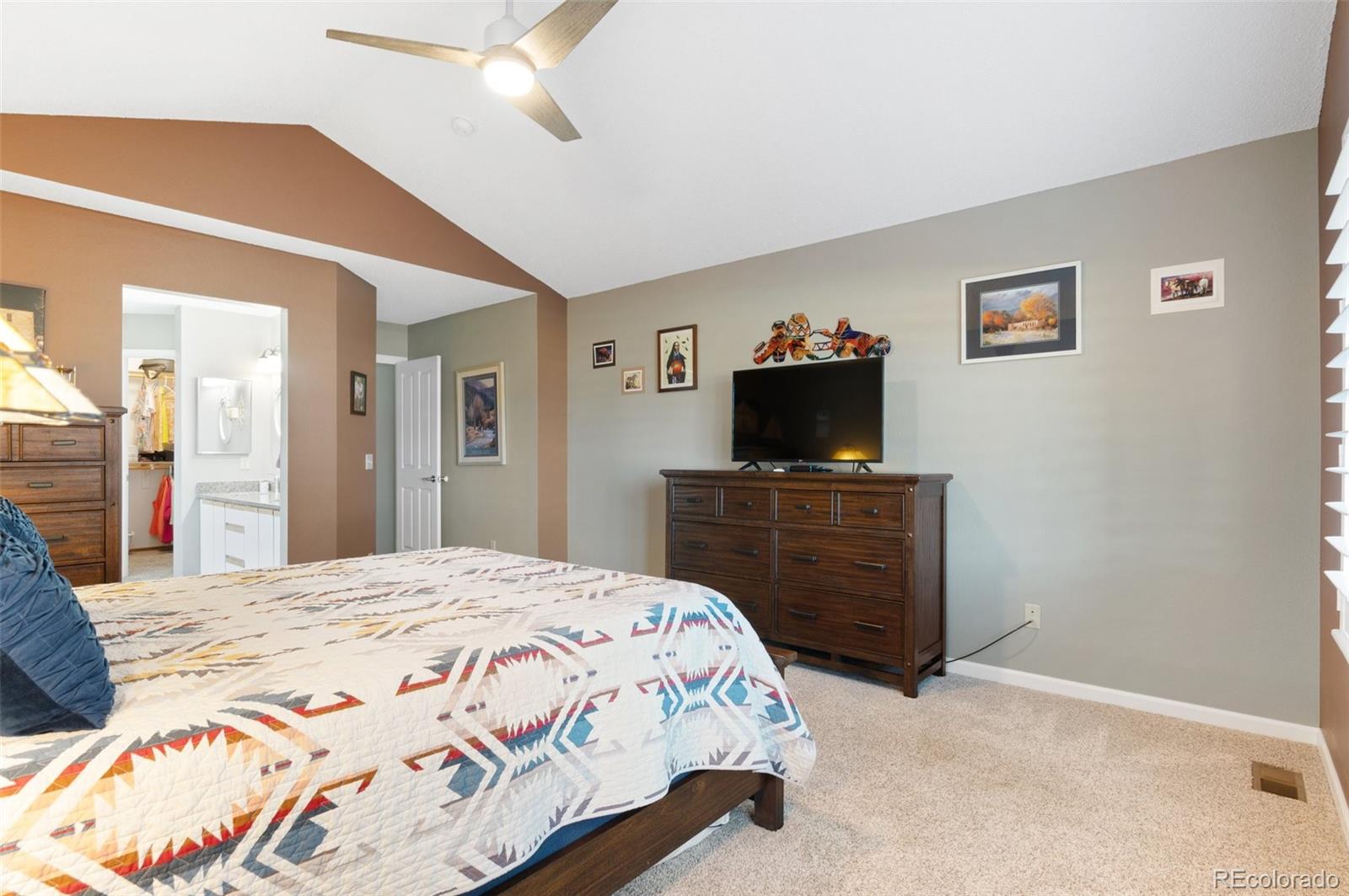 9836 Buckingham Court Highlands Ranch, CO 80130 - Photo 26 of 42 a bedroom with a bed and a flat tv screen on dresser