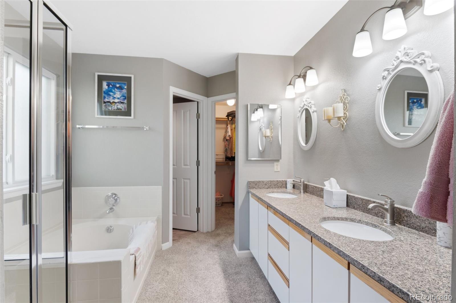 9836 Buckingham Court Highlands Ranch, CO 80130 - Photo 27 of 42 a spacious bathroom with a granite countertop double vanity sink and a mirror