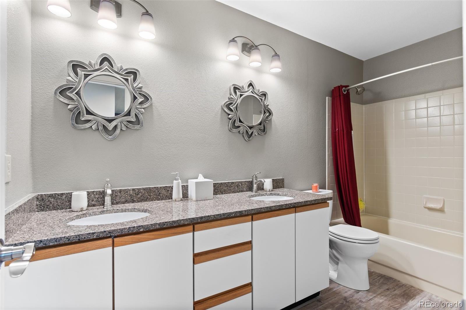 9836 Buckingham Court Highlands Ranch, CO 80130 - Photo 33 of 42 a bathroom with a sink a toilet and a mirror