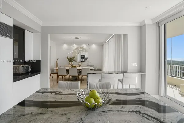a kitchen with stainless steel appliances granite countertop a stove a sink a microwave a refrigerator and white cabinets