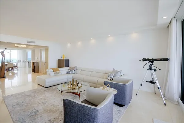 a view of a dining room and livingroom with furniture wooden floor and a rug