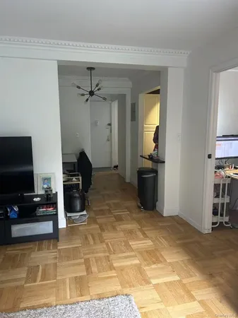 a living room with furniture a flat screen tv and kitchen view