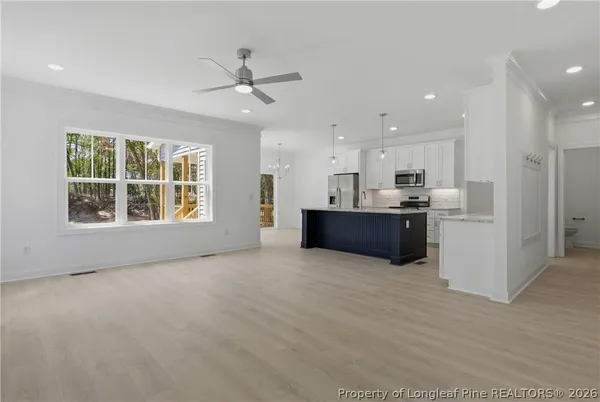 a kitchen with kitchen island granite countertop a sink cabinets and stainless steel appliances