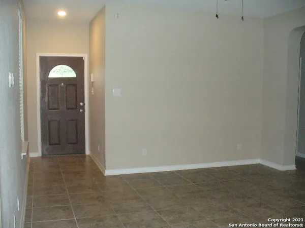 an empty room with wooden floor and mirror
