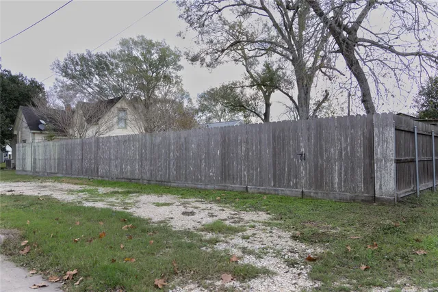 a view of a yard with wooden fence