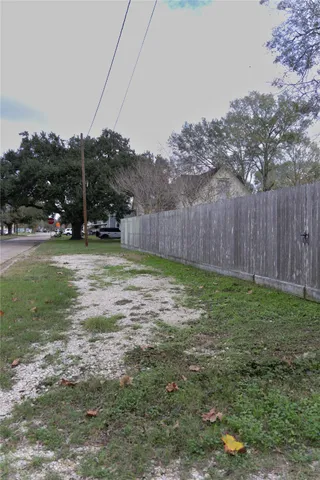 a view of a backyard with potted plants and large trees