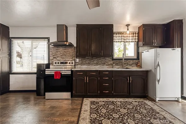 a view of a kitchen with wooden floor and cabinets