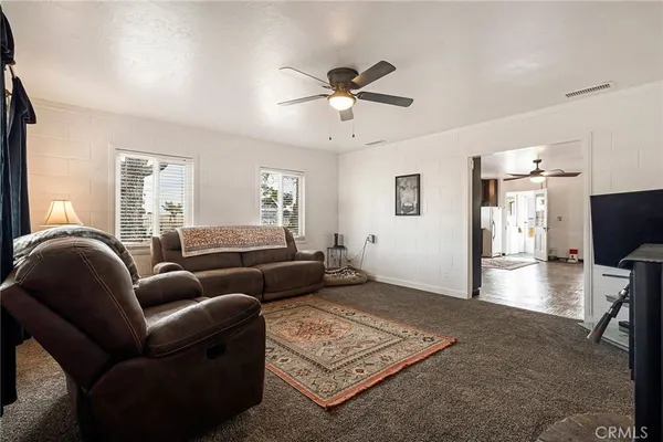 a living room with furniture a clock on wall and a window