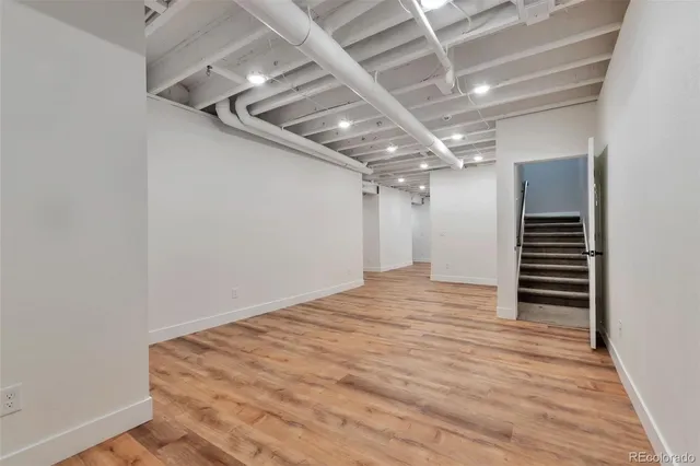 a living room with furniture a flat screen tv and gym equipment