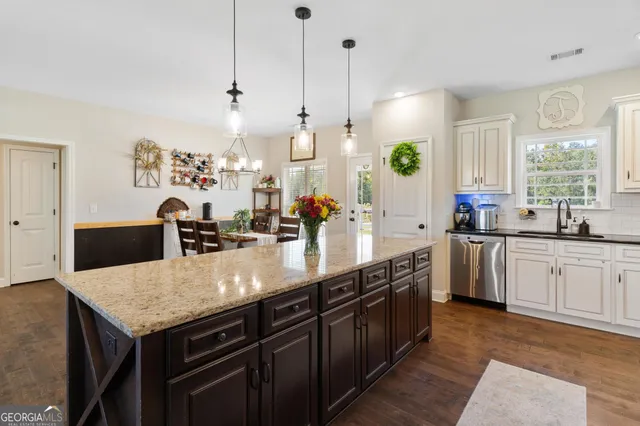 a large kitchen with kitchen island a stove a sink a center island and windows