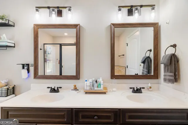 a bathroom with double vanity sinks and two mirror