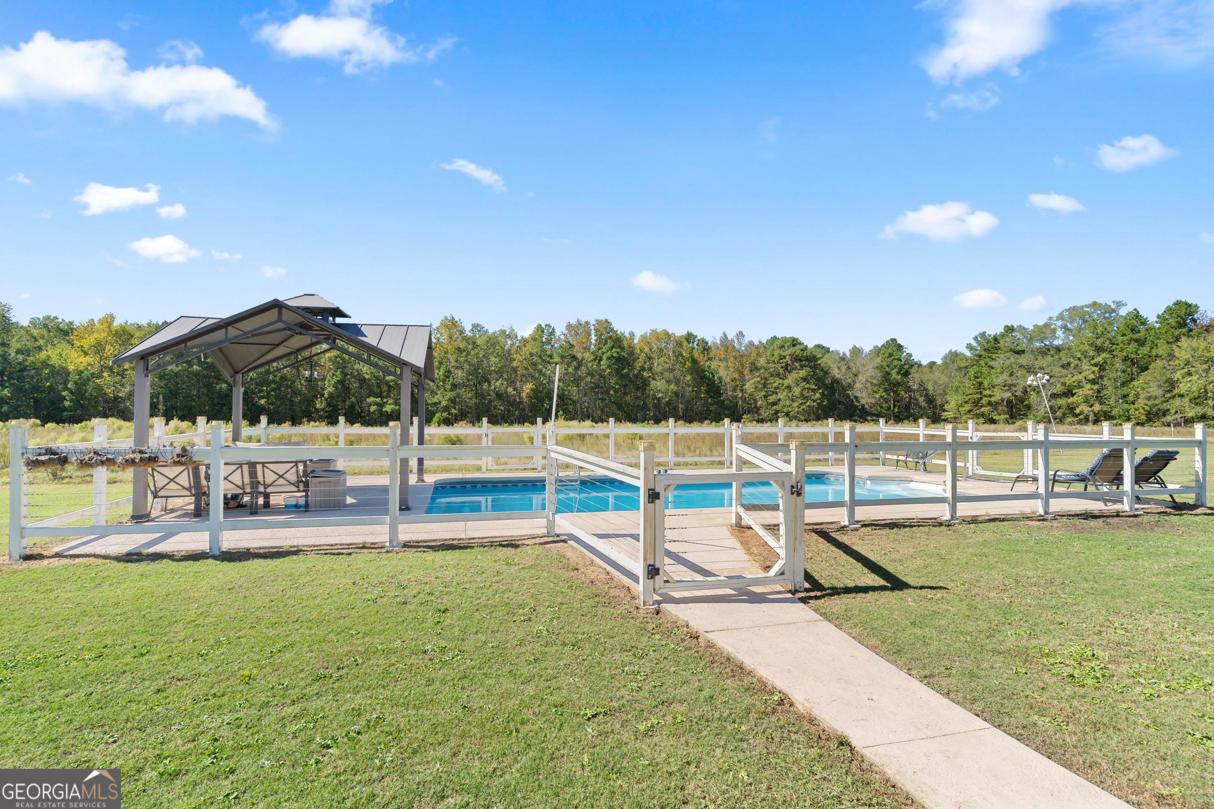 1287 Idlewood-Munnerlyn Road Waynesboro, GA 30830 - Photo 34 of 48 a view of a swimming pool with a patio and a yard