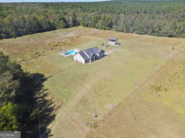 a view of a dry yard with wooden fence