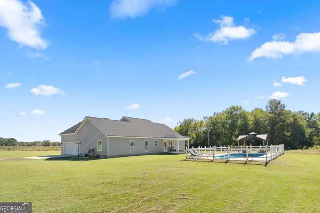 a view of a house with pool and a yard