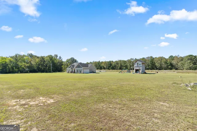 a view of a house with a yard and a lake view