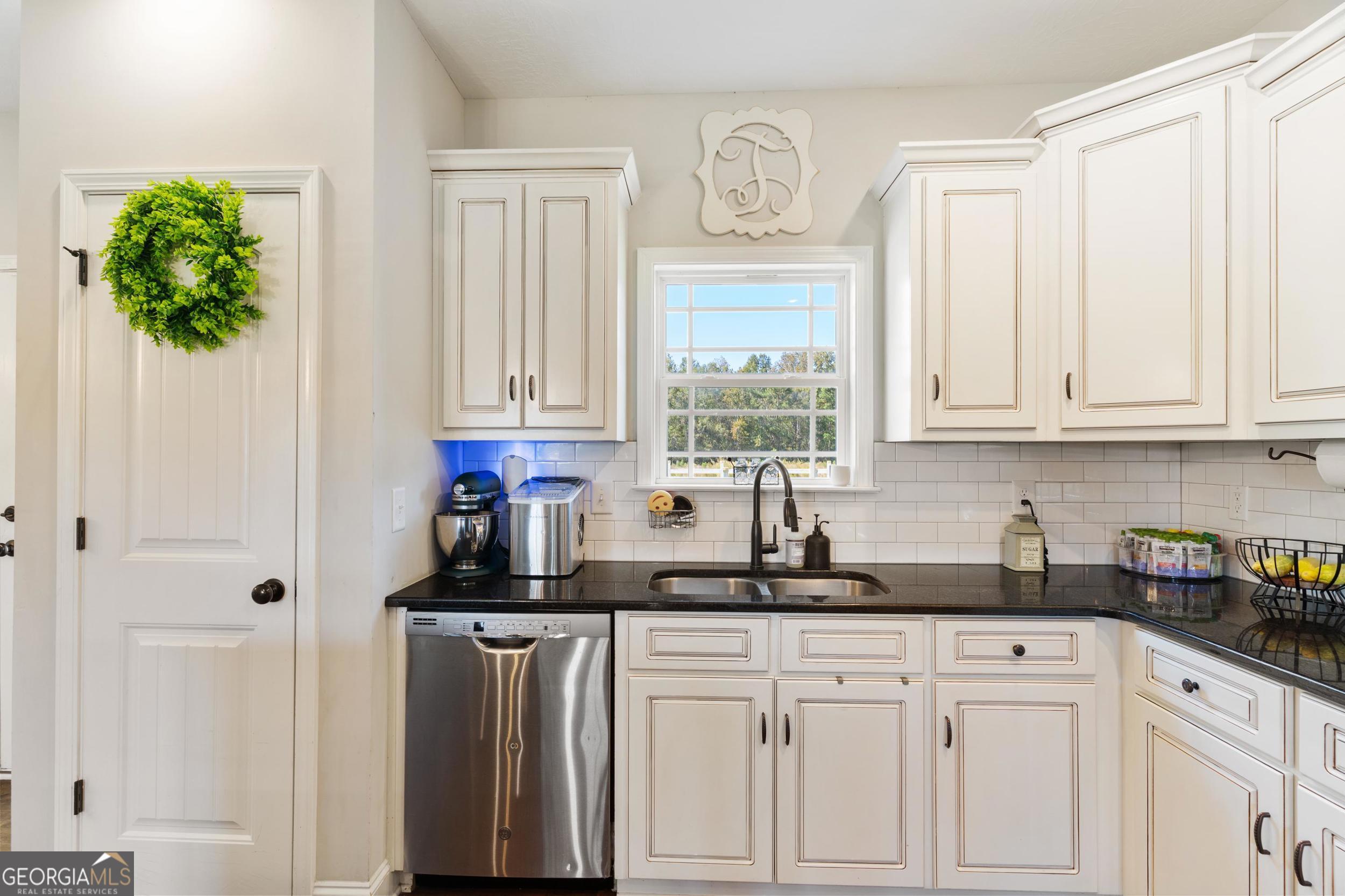 1287 Idlewood-Munnerlyn Road Waynesboro, GA 30830 - Photo 10 of 48 a kitchen with white cabinets and window