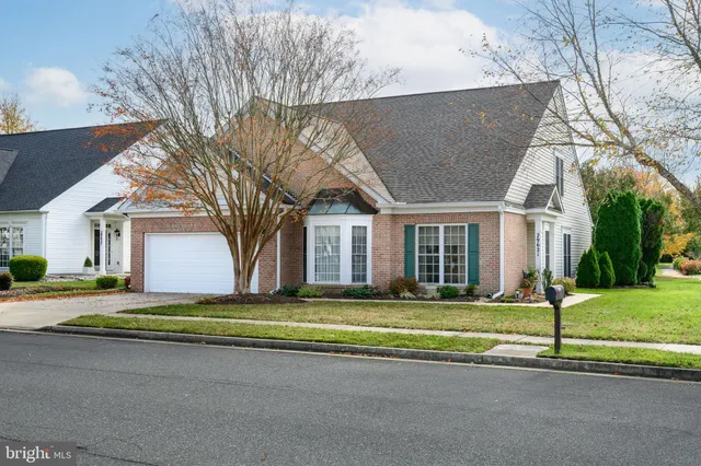 a view of a house with a big yard and large trees