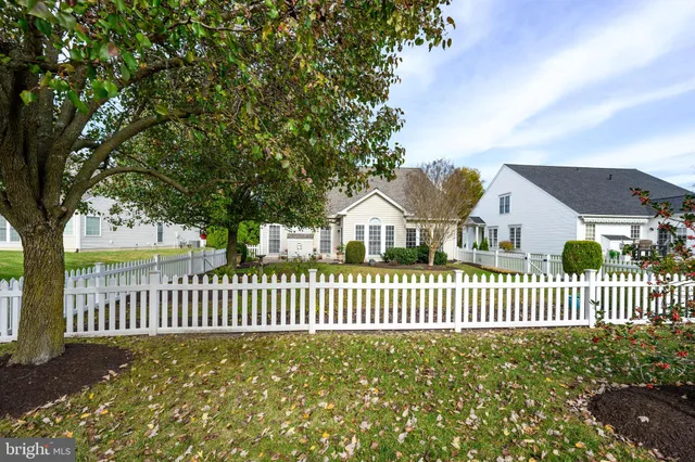 a view of a house with a small yard and wooden fence